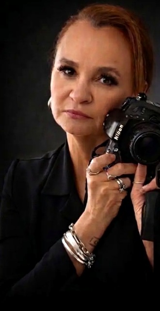 Renata, fotógrafa, segurando sua câmera Nikon